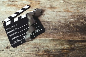 A film clapperboard with a roll of film on top.