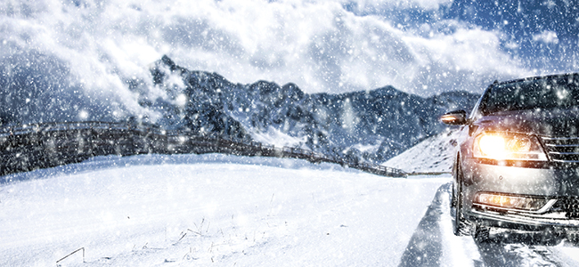 A car drives through the snow. 